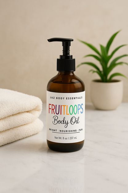 Bottle of Jaz Body Essentials Fruitloops Body Oil on a neutral background with a towel and plant.