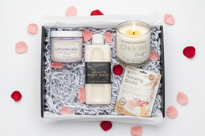 Gift set with candles, body wash, and other products on a white background with rose petals.