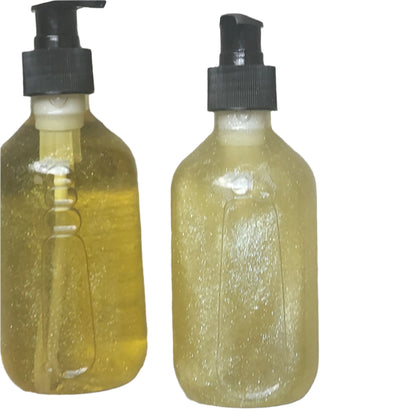 Two bottles of yellow liquid with black pumps on a gray surface