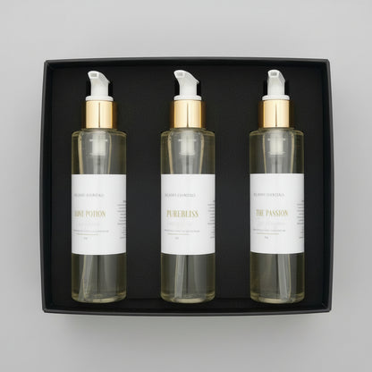 Three skincare bottles with gold and white pumps in a box.