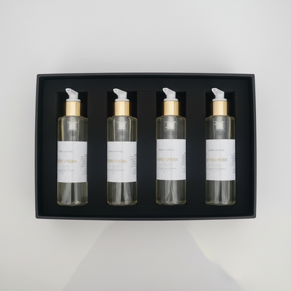 Three skincare bottles with gold and white pumps in a box.