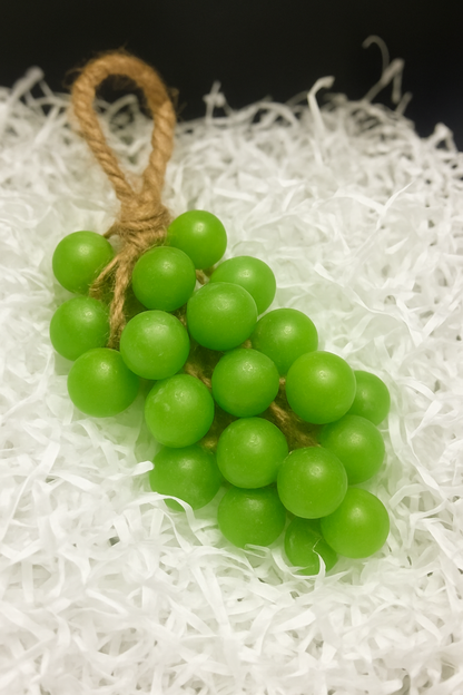 Bunch of green grapes tied with twine on a white textured surface